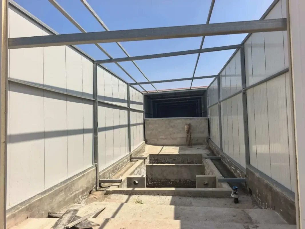 部分封闭建筑内未完工的矩形混凝土池。